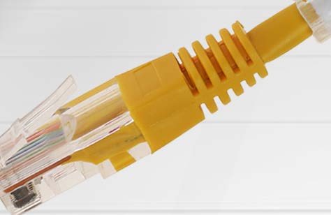 Close-up of a yellow RJ45 patch lead with a TagPro label fitted behind the connector boot